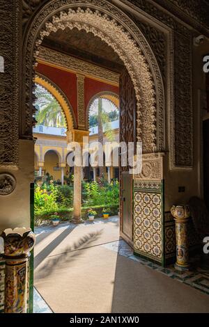 Gli elaborati archi in multifoglio conducono al patio principale del Palacio de las Dueñas Foto Stock