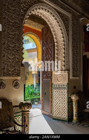 Gli elaborati archi in multifoglio conducono al patio principale del Palacio de las Dueñas Foto Stock