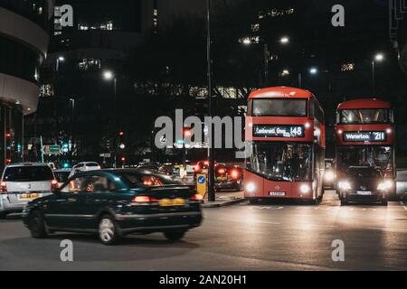 London, Regno Unito - 24 Novembre 2019: Red double decker bus e auto su una strada di Londra nella sera, motion blur. Gli autobus sono parte integrante del T.R.A. Foto Stock