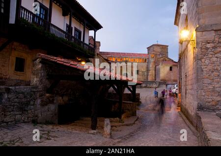 Strada e chiesa collegiata, Vista notte. Santillana del Mar, Cantabria, Spagna. Foto Stock