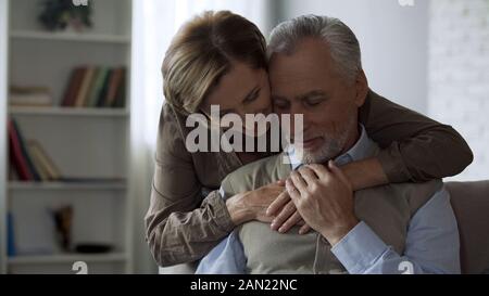 Pensionato lady abbracciando l uomo, amare le relazioni a lungo il matrimonio, la vicinanza e la cura Foto Stock