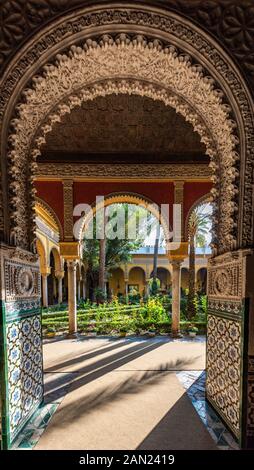 Il patio andaluso in stile Palm Tree Courtyard del Palacio de las Dueñas attraverso archi Mudéjar decorati con ornamento Foto Stock