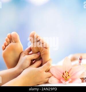 Chiudere la riflessologia plantare. Podiatrist il massaggio del piede femminile contro lo sfondo colorato. Foto Stock
