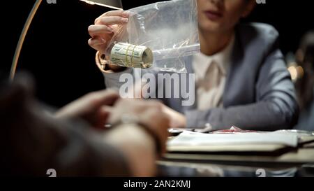 Detective femmina che mostra il denaro a sospettare, interrogazione del concessionario di farmaco Foto Stock
