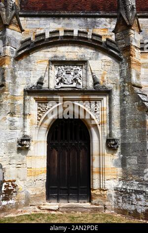 Ingresso laterale alla chiesa parrocchiale di San Giovanni Battista, con sopra lo stemma della famiglia Sidney, Penshurst, Kent, Inghilterra Foto Stock