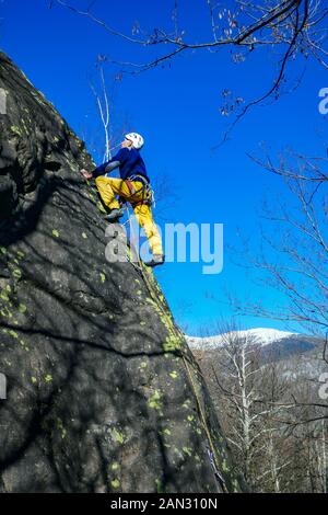 Maschio di rocciatore, 70 anni, arrampicata su roccia di granito a Auzat, Pirenei francesi, Francia Foto Stock