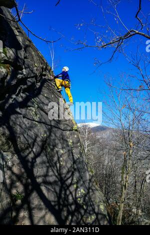 Maschio di rocciatore, 70 anni, arrampicata su roccia di granito a Auzat, Pirenei francesi, Francia Foto Stock