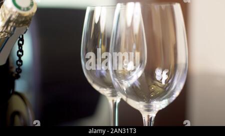 Due wineglasses vuota e bottiglia di champagne in piedi sul tavolo, celebrazione Foto Stock