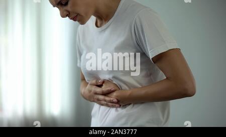 Donna di mezza età che soffrono di mal di stomaco, avvelenamento alimentare, la cura della salute Foto Stock