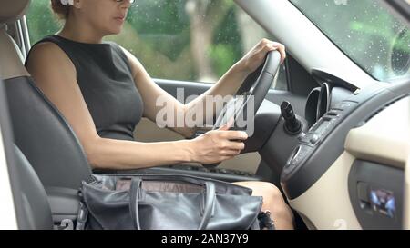 Grave business donna in auto di lusso guida su importante incontro ravvicinato Foto Stock
