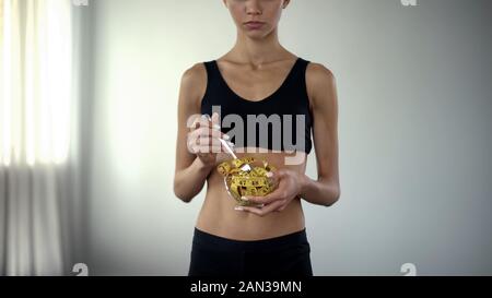 Montare donna mangiare nastro di misurazione, il concetto di controllo di BMI, restrizioni alimentari Foto Stock