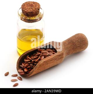Semi di lino e l'olio in un recipiente su sfondo bianco Foto Stock