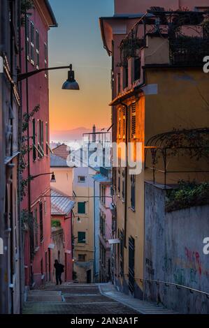 Genova, Genova: Lanterna (faro) vista dalla caratteristica colorati tipici vicoli stretti (caruggi, vicoli) e colorate case della città vecchia Foto Stock