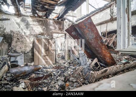 Le conseguenze di un incendio in un complesso industriale il giorno successivo Foto Stock