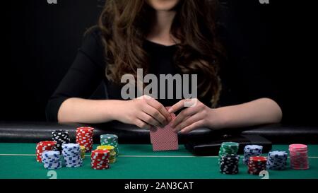 Casino femmina lettore schede controllo combinazione, donna l assunzione di rischi nel gioco di poker Foto Stock