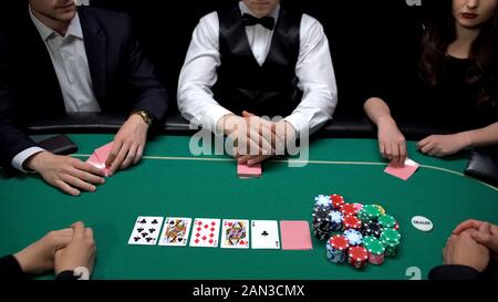 Giocatori di Poker di controllare le combinazioni di mano a elite casino, classe superiore il gioco d'azzardo Foto Stock