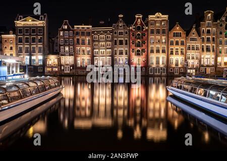 Amsterdam canal Singel con tipiche case olandese e case galleggianti durante la notte, Holland, Paesi Bassi. Foto Stock