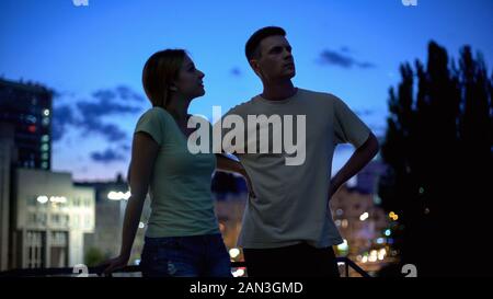 Giovane uomo e donna parlando seriamente, sera Tempo libero in città, amici Foto Stock
