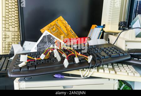 Computer scartati i pezzi di ricambio. E-catasta di rifiuti dettaglio dall'hardware elettronico componenti PC come tastiere, stampante, monitor. I cavi colorati, schede madre. Foto Stock