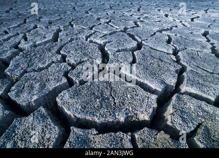 Abstract grigio rotto arida terra. Siccità in suolo dettaglio texture. L'eco di sottofondo morti di terra bruciata. Il cambiamento climatico, disastri naturali o nucleari. Foto Stock