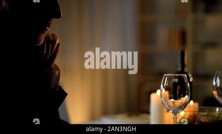 Bello il senior uomo in tuta di attesa per la donna nel ristorante, data romantico Foto Stock