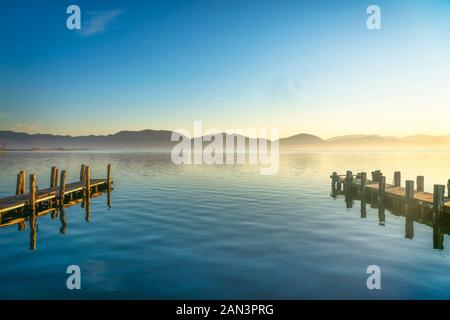 Due pontili in legno o banchine e il lago di sunrise. Torre del Lago Puccini, Versilia, il lago di Massaciuccoli, Toscana, Italia, Europa Foto Stock