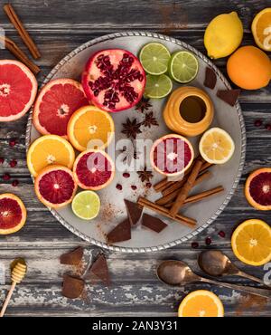 Vista dall'alto in basso di un astratto collage di agrumi lungo con cannella, il miele e il cioccolato. Foto Stock