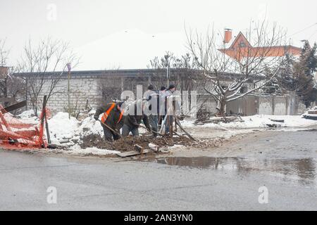 Città del servizio di emergenza di riparazione rottura tubo acqua in inverno. Foto Stock