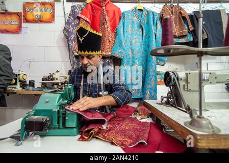 5 marzo 2019: un anziano uomo su misura in un utilizzando una macchina da cucire. Yazd, Iran Foto Stock