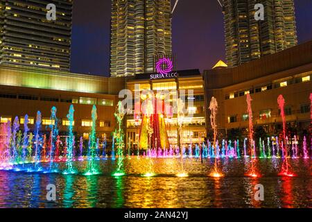 Fontane danzanti multicolore vicino alle torri gemelle di Petronas a Kuala Lumpur. Foto Stock