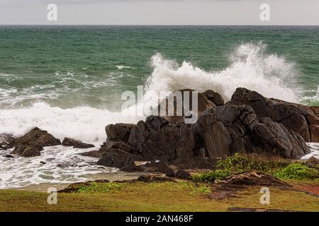 Galle, Sri Lanka, Settembre 2015: arrabbiato onde infrangersi sulle rocce della costa durante una tempesta estiva Foto Stock