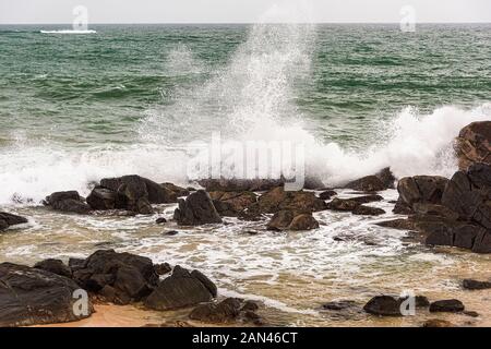 Galle, Sri Lanka, Settembre 2015: arrabbiato onde infrangersi sulle rocce della costa durante una tempesta estiva Foto Stock