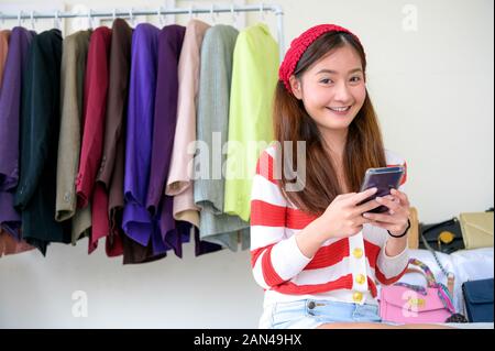 Bellezza Vlogger asiatici blogger vendita di abiti donna e borsa online durante utilizzo telefono su social media. Donna trading coaching e prodotto di revisione. Busin Foto Stock