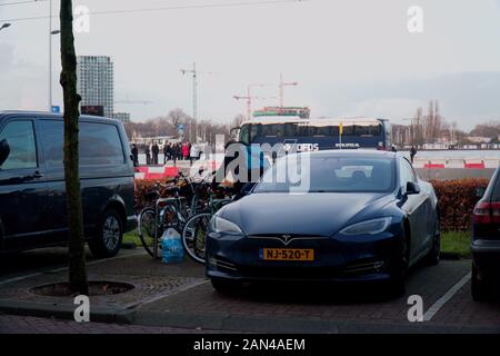 Tesla Model S parcheggiate accanto alle biciclette in Amsterdam, Paesi Bassi Foto Stock
