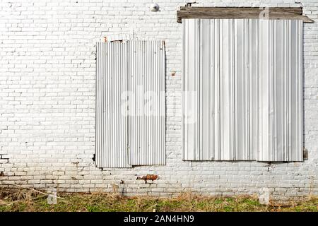 Bianco vecchio muro di mattoni sulla parete esterna del vecchio mulino nel Midwest. Foto Stock
