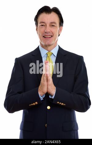 Studio shot di matura happy businessman sorridente con le mani incrociate Foto Stock