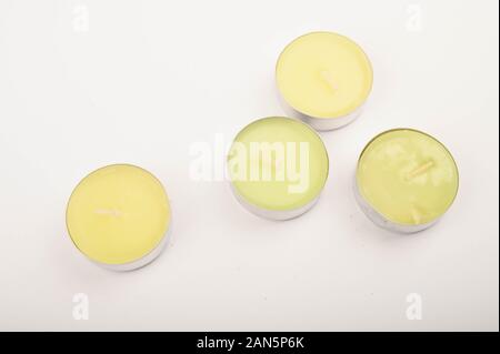 Diverse candele colorate in involucri di alluminio su sfondo bianco. Primo piano Foto Stock