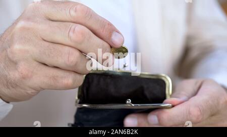 Senior man mano messa cent wallet, risparmiare denaro, il pensionamento e budget Foto Stock