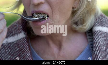 Old Lady mangiare porridge, carità pasti per pensionati poveri, riforma sociale Foto Stock