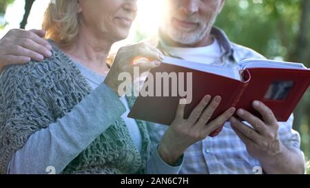 Momenti felici, adulti Genitori ammirando le foto in album di famiglia ricordando la gioventù Foto Stock