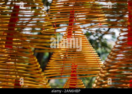 Primo piano di bobine di incenso / spirali. Catturato al tempio DI A-ma. Sfondo blu e verde. Incenso bruciante è comune nei templi nei paesi asiatici. Foto Stock