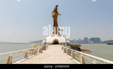 Ponte / percorso che conduce verso la statua Kun Iam (noto anche come Guan Yin o Guanyin - una bodhisattva femminile). Sullo sfondo il mare e il cielo di Macao Foto Stock