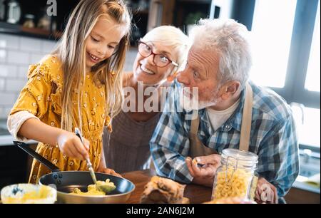 Felici i nonni con i nipoti facendo colazione in cucina Foto Stock