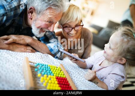 Felice nonni avente tempi di divertimento con i bambini a casa Foto Stock