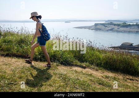 White woman in bikini camminando lungo la costa il percorso Foto Stock