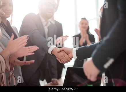 Business Partner stringono le mani in piedi in ufficio. Foto Stock