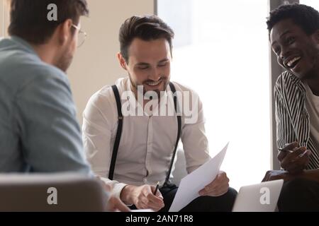 Sorridente business millenario i colleghi che hanno collaborato alla riunione del team Foto Stock
