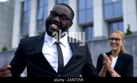 Imprenditore divertenti happy per ottenere la promozione, celebrando il successo, supporto del team Foto Stock