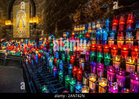 Montserrat, Catalogna, Spagna - candele accese lungo la parete nell'Abbazia di Montserrat Foto Stock