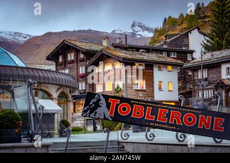 Zermatt, Svizzera - tenendo un famoso cioccolato svizzero Toblerone con la foto del Monte Cervino e il monte reale nella parte posteriore Foto Stock